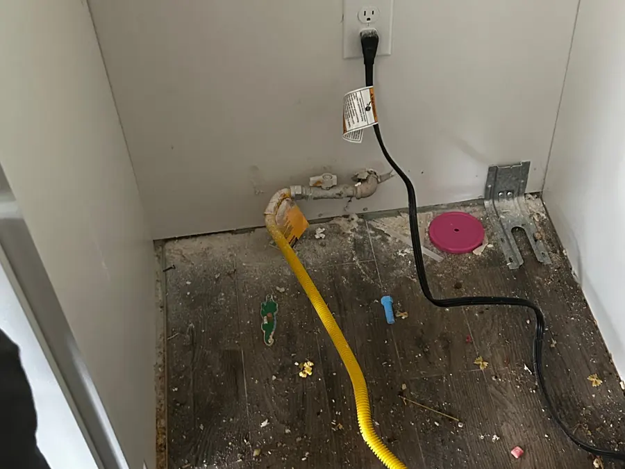 Bare subfloor covered in construction debris and cable before a post-construction cleanup